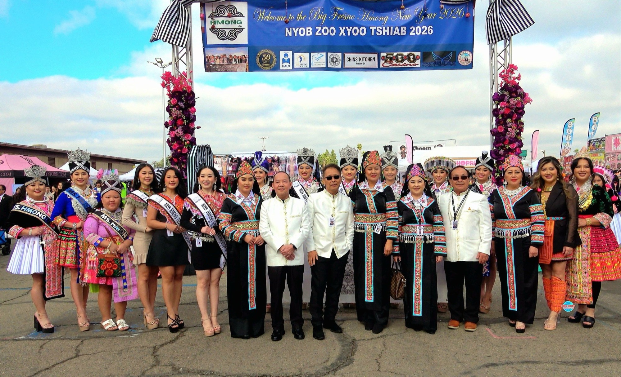 The welcome arch reading Nyob Zoo Xyoo Tshiab 2026, with the festival delegation and titleholders beneath it.