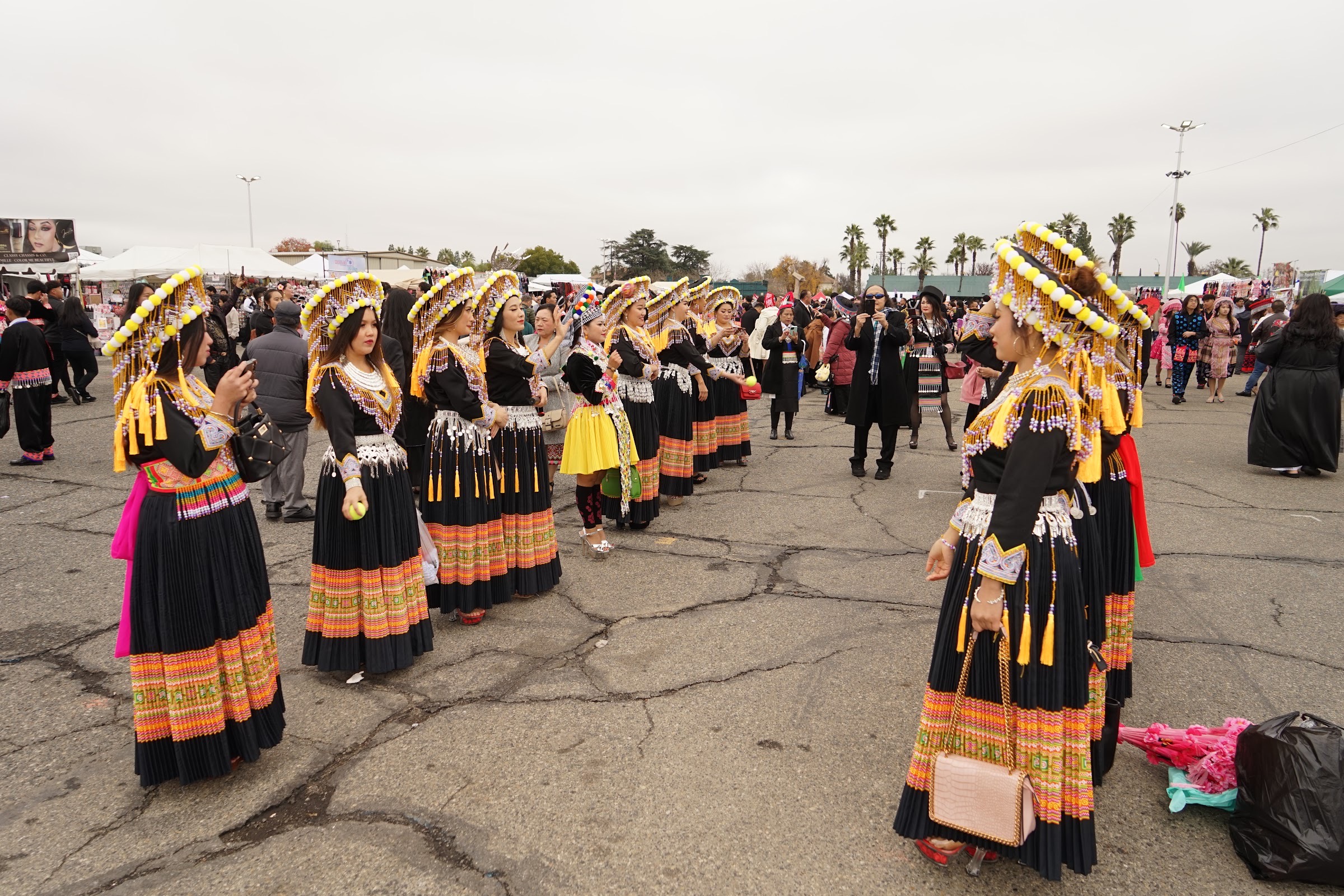 Dancers in full Hmong dress lined up on the fairgrounds before a performance.