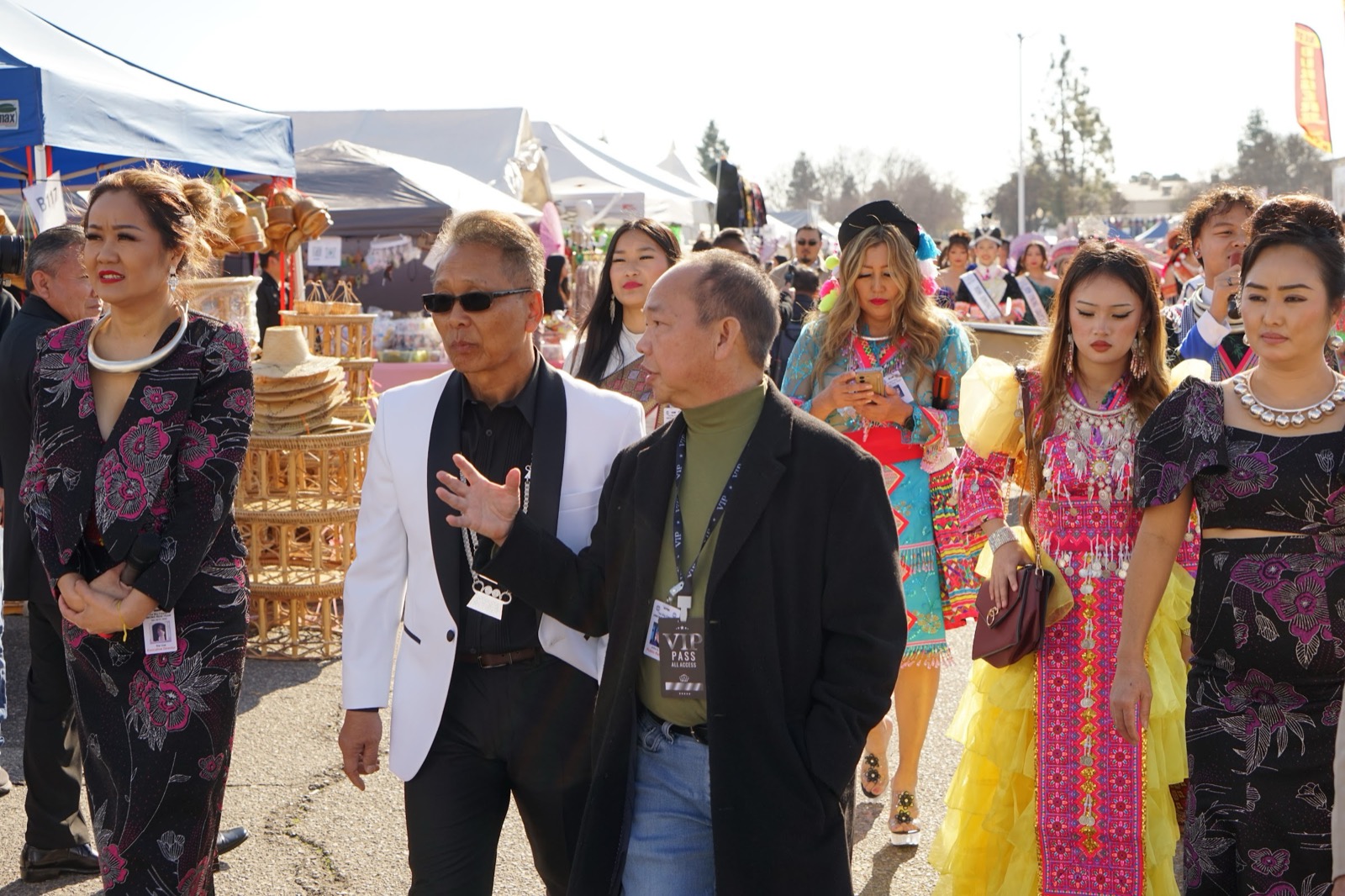 Shoppers moving through the festival marketplace past vendor stalls.